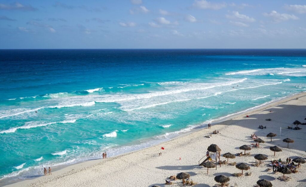 A tranquil beach in Cancun, Mexico, with few visitors and stunning shades of blue in the crystal-clear Caribbean waters.