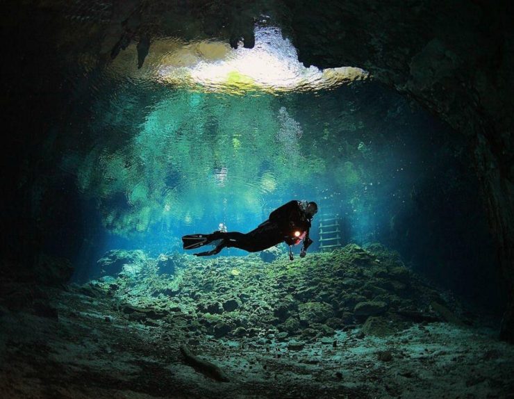 Buzo nadando en el Gran Cenote de Tulum